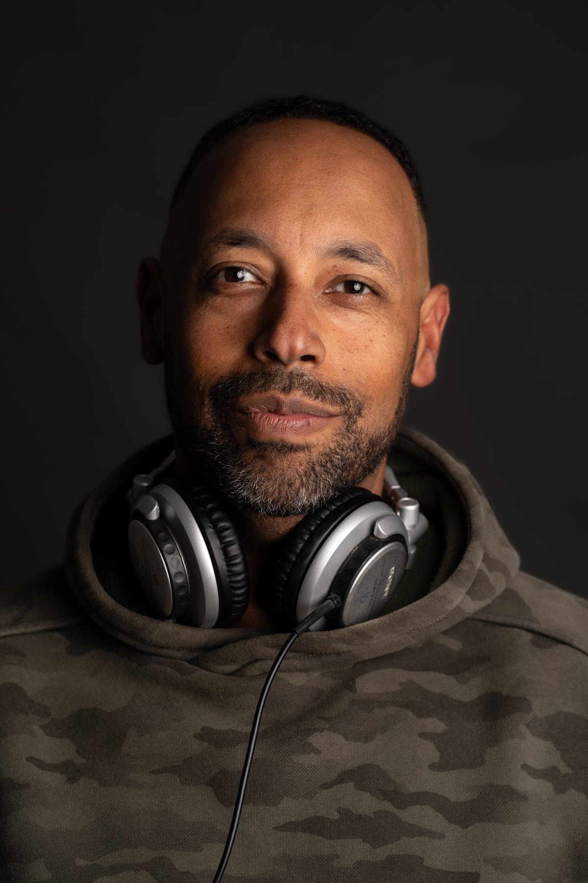 Matt Cox smiling with headphones around his neck