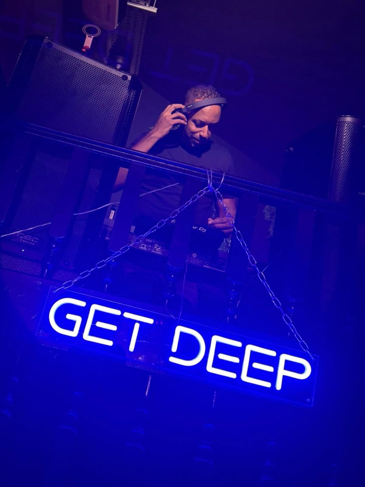 Matt Cox DJing beneath a blue Get Deep sign
