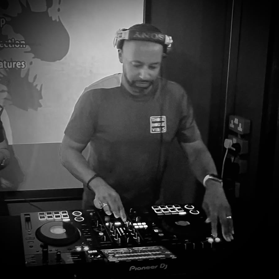 Black-and-white photograph of Matt Cox mixing on Pioneer DJ equipment