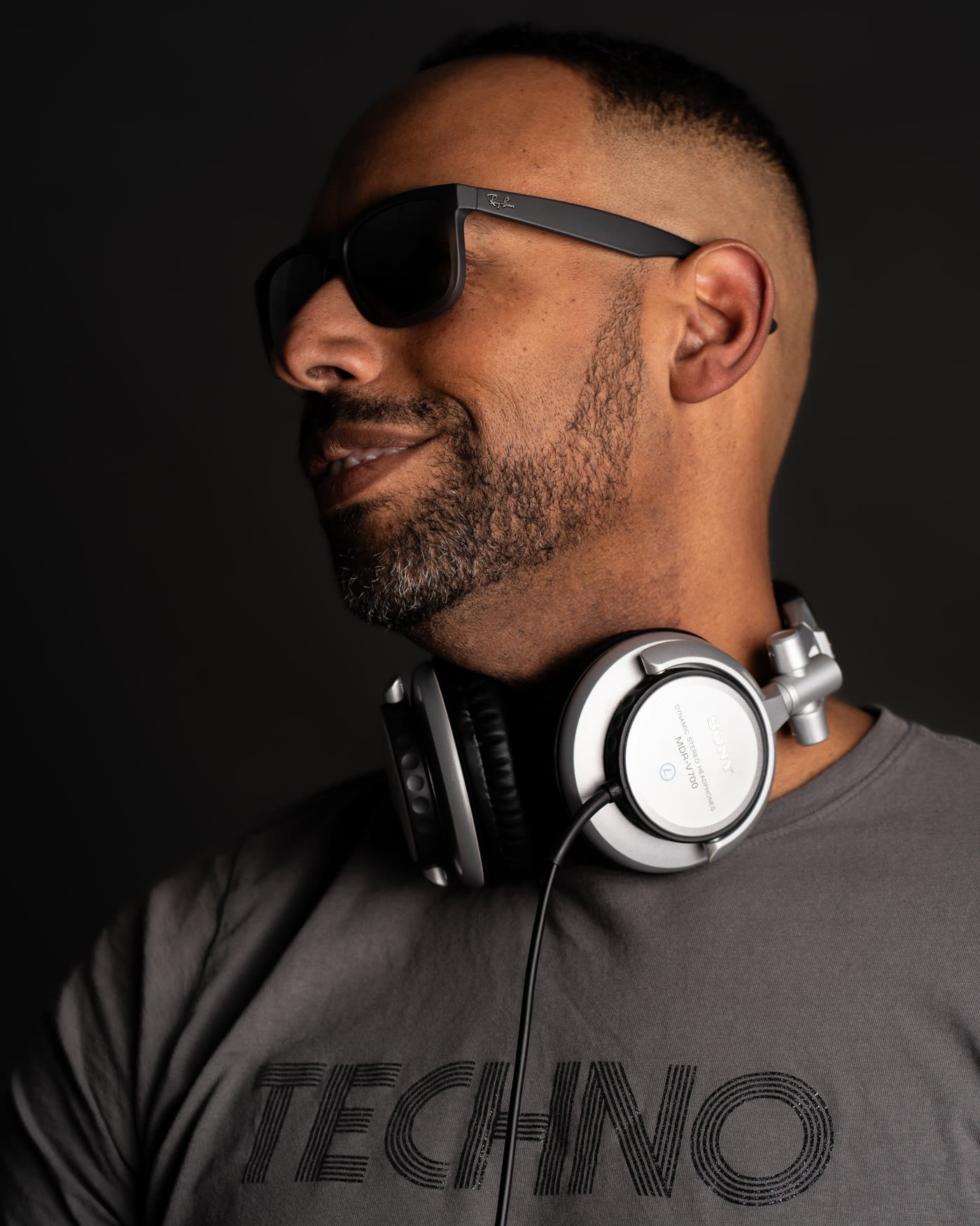 Side profile of Matt Cox in sunglasses with headphones around his neck